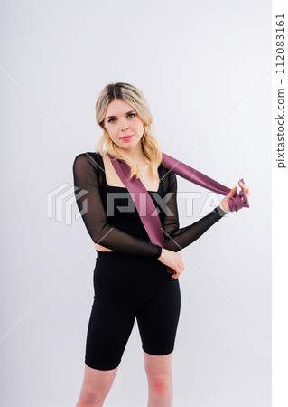 Young woman workout with resistance band on white background. Strength and motivation. 112083161