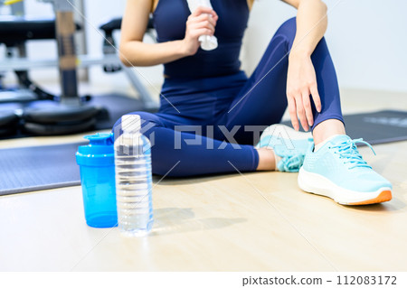 Young woman training her body at a personal gym, taking a break, background material, muscle training girl, indoor color Young woman training her body at a personal gym, taking a break, background material, muscle training girl, indoor color 112083172