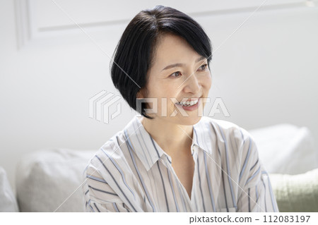 一個 50 歲出頭微笑的女人的肖像 112083197