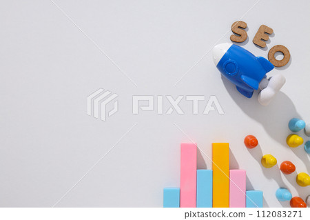 Diagram, letters and toy rocket on light background, space for text 112083271