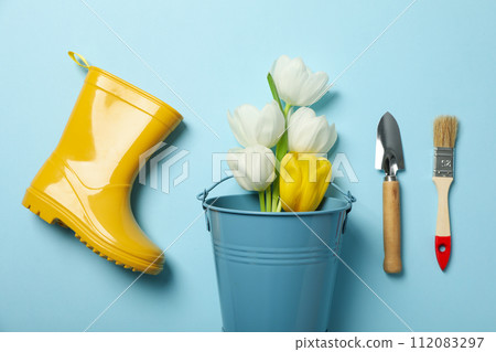 Gardening supplies, rubber boot and tulips on blue background, top view 112083297