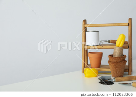 Garden supplies, can of paint and tulips on light background, space for text 112083306