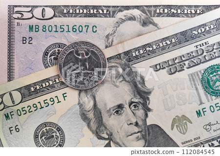 Quarter dollar coin on top of a 20 and 50 banknotes Quarter dollar coin on top of a 20 and 50 banknotes 112084545
