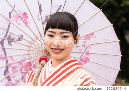 一個穿著日式服裝的女人站在花園裡 112084844