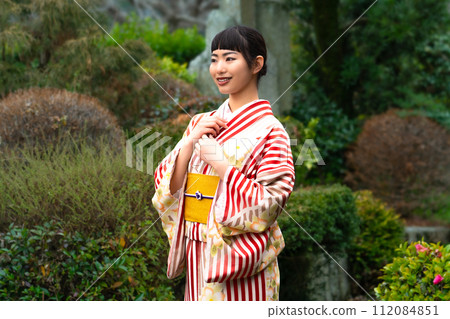 一個穿著日式服裝的女人站在花園裡 112084851