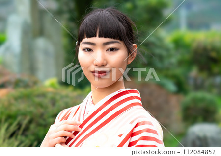 一個穿著日式服裝的女人站在花園裡 112084852
