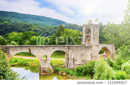 Romanesque bridge over the Fluvia river at Besalu, Girona, Catalonia. 112084927