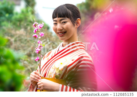 一個穿著日式服裝的女人站在花園裡 112085135