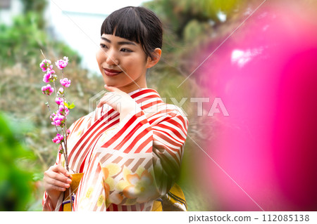 一個穿著日式服裝的女人站在花園裡 一個穿著日式服裝的女人站在花園裡 112085138