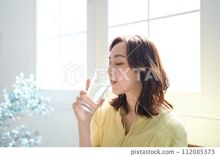 A woman drinking water A woman drinking water 112085373