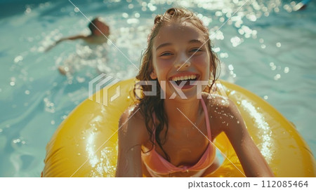 Laughing girl in pool with float 112085464
