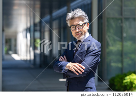 Senior male business arms crossed 112086014