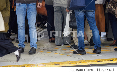 View of passengers on a crowded commuter train station platform on a winter morning 112086421