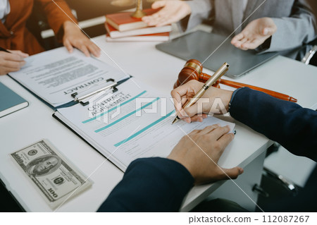 Legal counsel presents to the client a signed contract with legal law. justice and lawyer concept in office. 112087267