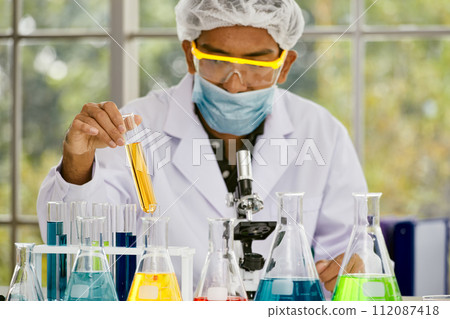 One Scientist Evaluates Test Tube Sample in Lab; Focused Examination in Research Lab 112087418