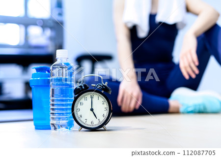 Young woman training at a personal gym Clock and time Background material Muscle training girl Cool colors Clear 112087705