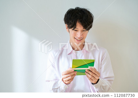 年輕人看著他的銀行存摺 年輕人看著他的銀行存摺 112087730