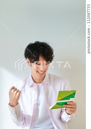年輕人看著他的銀行存摺 年輕人看著他的銀行存摺 112087733