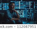 thoughtful computer scientist sitting in front of a computer system 112087951