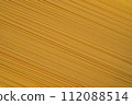 Diagonal Spaghetti Pasta on Yellow Background 112088514