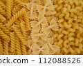 Variety of Uncooked Pasta on Yellow Background 112088526