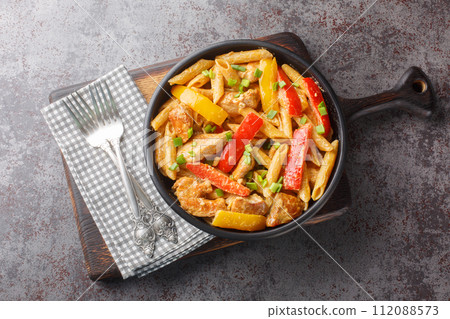 Jamaican Style Rasta Pasta Penne with Grilled Chicken and Bell Peppers closeup on the bowl. Horizontal top view Jamaican Style Rasta Pasta Penne with Grilled Chicken and Bell Peppers closeup on the bowl. Horizontal top view 112088573
