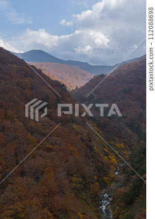 從日本青森縣青森市十和田八幡平國立公園的城倉大橋看到的城倉溪和八甲田山脈的秋葉 112088698