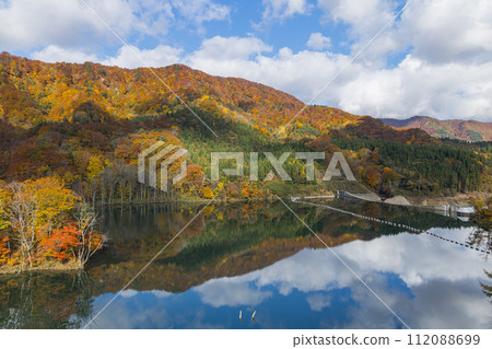 從日本青森縣中津輕郡大川白神橋上看到的安門河和秋葉倒映在鏡子裡 112088699