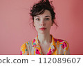 young woman dressed in colorful shirt with collected hair and red lips 112089607
