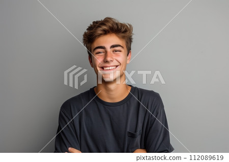 Smiling young brown-haired man on gray background Smiling young brown-haired man on gray background 112089619