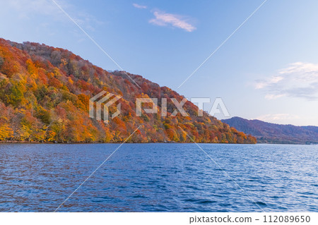 Lake and autumn leaves at dusk as seen from Nenokuchi Port on Lake Towada, Towada City, Aomori Prefecture, Japan 112089650
