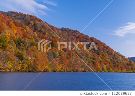 Lake and autumn leaves at dusk as seen from Nenokuchi Port on Lake Towada, Towada City, Aomori Prefecture, Japan 112089652