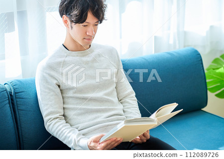 A young man reading a book 112089726