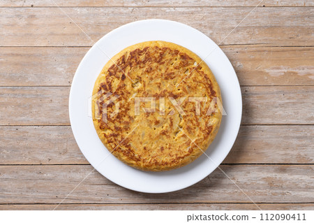 Traditional spanish omelette on wooden table 112090411