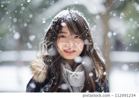 Portrait of a young woman standing in the falling snow Portrait of a young woman standing in the falling snow 112091234