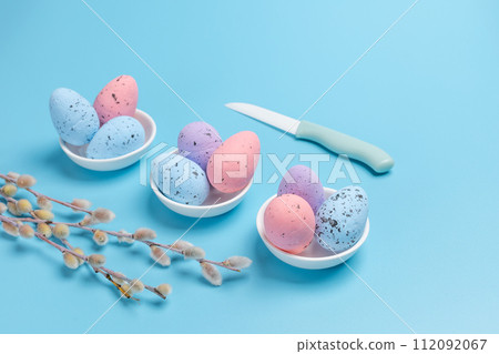 Saucers with colored Easter eggs on the blue background. Saucers with colored Easter eggs on the blue background. 112092067