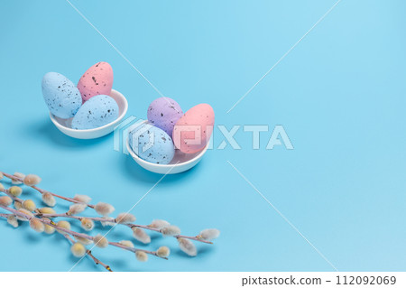 Saucers with colored Easter eggs on the blue background. Saucers with colored Easter eggs on the blue background. 112092069