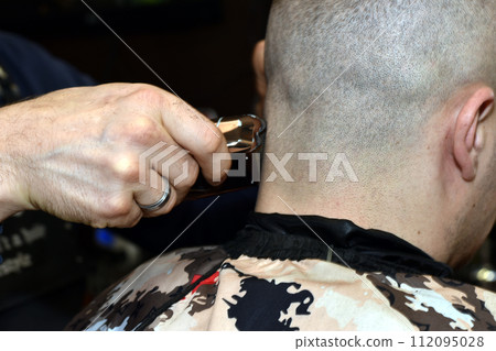 A barber shaves a client's neck. A barber shaves a client's neck. 112095028