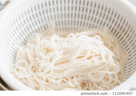 Somen noodles boiled and drained in a colander 112095407