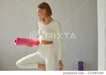Young sporty smiling woman posing with yoga mat after yoga class. Yoga coach, yoga teacher.Young sporty smiling woman posing with yoga mat after yoga class. Yoga coach, yoga teacher. 112097204