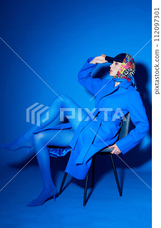 fashion portrait of young elegant woman in blue coat. 112097301