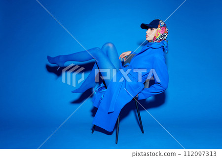 fashion portrait of young elegant woman in blue coat. 112097313