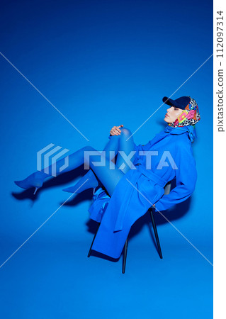 fashion portrait of young elegant woman in blue coat. 112097314