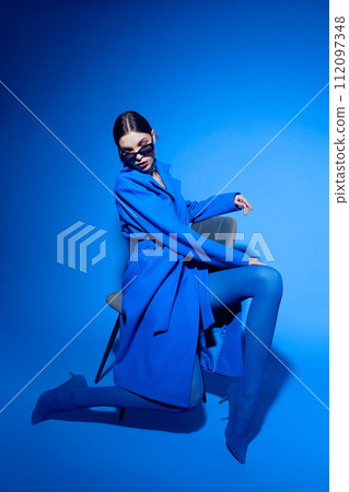 fashion portrait of young elegant woman in blue coat. 112097348