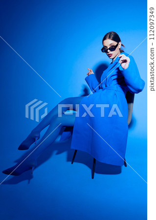 fashion portrait of young elegant woman in blue coat. 112097349