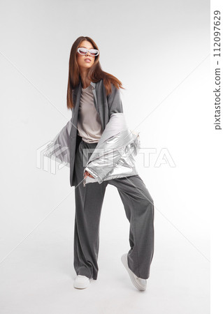 Fashion asian female model in silver down jacket and grey suit. Fashion asian female model in silver down jacket and grey suit. 112097629
