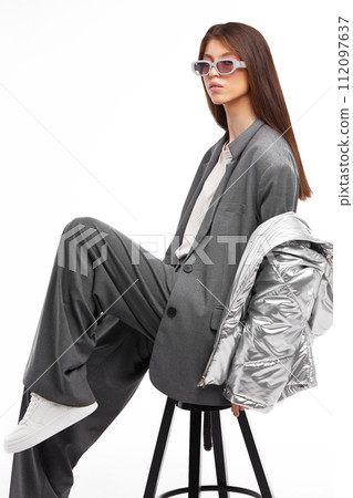 Fashion asian female model in silver down jacket and grey suit. 112097637