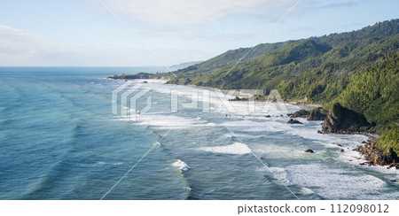 Rough exotic coast with azure ocean water, big waves and rainforest vegetation, New Zealand Rough exotic coast with azure ocean water, big waves and rainforest vegetation, New Zealand 112098012