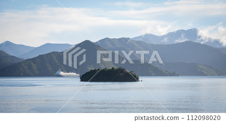 Wide view on big transport ship ferry sailing through green fjords, New Zealand 112098020