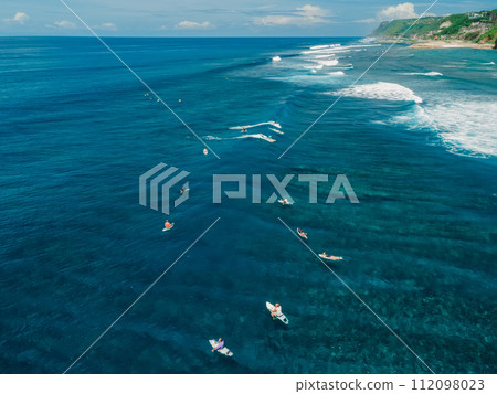Aerial view with surfers on surf spot in blue ocean 112098023